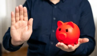 Homem de camisa azul nervoso segurando cofrinho vermelho, símbolo da falta de planejamento financeiro e necessidade de consultoria financeira pessoal
