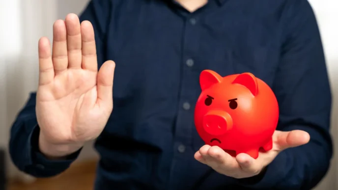 Homem de camisa azul nervoso segurando cofrinho vermelho, símbolo da falta de planejamento financeiro e necessidade de consultoria financeira pessoal