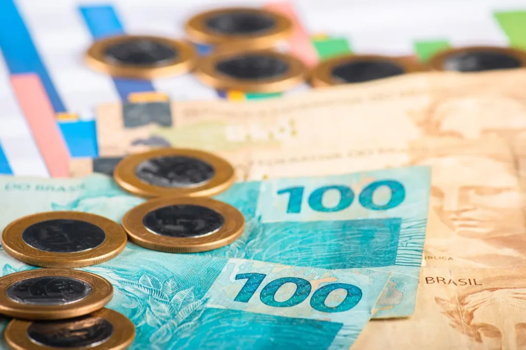 Notas de dinheiro sobre mesa com documentos, ilustrando organização patrimonial e consultoria financeira.