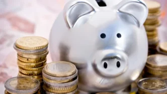 Cofrinho prateado com moedas ao lado simbolizando um novo ano e novas oportunidades de saúde financeira da Ibovespa