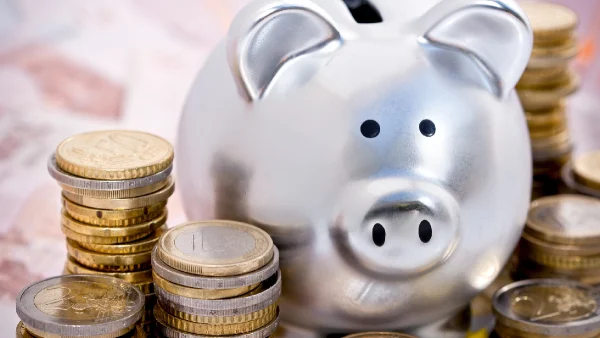 Cofrinho prateado com moedas ao lado simbolizando um novo ano e novas oportunidades de saúde financeira da Ibovespa