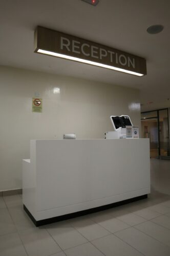 Balcão de recepção moderno de um centro médico, com placa sinalizadora acima