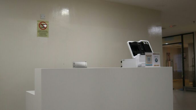 Balcão de recepção moderno de um centro médico, com placa sinalizadora acima